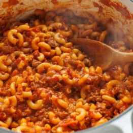 Dutch oven filled with American Chop Suey recipe with ground beef, tomatoes and elbow macaroni pasta
