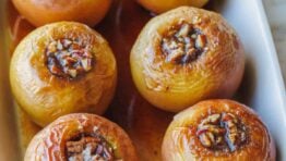 Baked apples filled with cinnamon sugar in a rectangular baking dish.