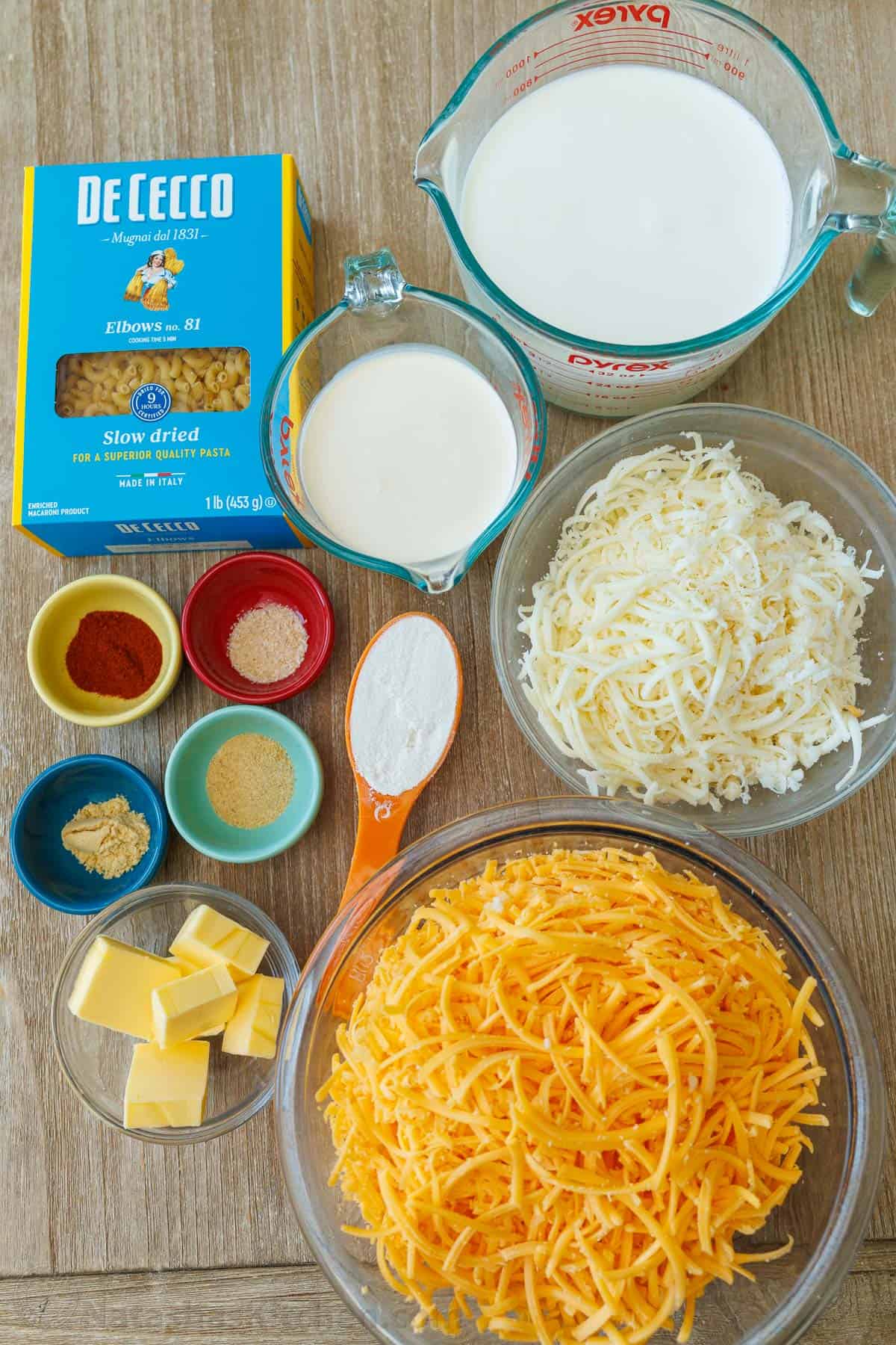 Ingredients for Baked Cheesy Pasta with elbows, whole milk, heavy cream, mozzarella, cheddar, paprika, garlic powder, onion powder, flour, mustard powder, and butter