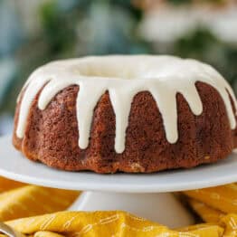 Glazed Banana Bundt Cake with a yellow table cloth and knife for cutting