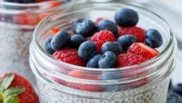 Simple chia seed pudding recipe in mason jars with berries on top