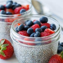 Simple chia seed pudding recipe in mason jars with berries on top