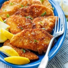 Chicken Schnitzel on a plate with lemon wedges