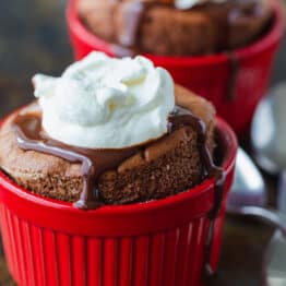 Chocolate souffle served in cups with whipped cream and chocolate sauce