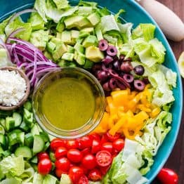 Chopped Greek Salad with Lettuce served in a blue bowl with dressing