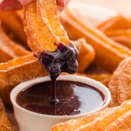 Dipping churro in chocolate sauce