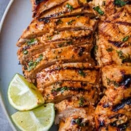 grilled chicken breasts in slices with lime slices