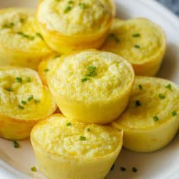Cottage Cheese egg bites recipe stacked on a white plate with chives on top