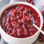 A bowl of homemade cranberry sauce with a spoon.
