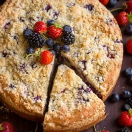 Berry Cake with 1 slice cut out garnished with mixed berries