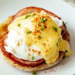 Eggs Benedict on a plate topped with hollandaise