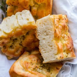 slices of rosemary garlic focaccia bread on a white towel