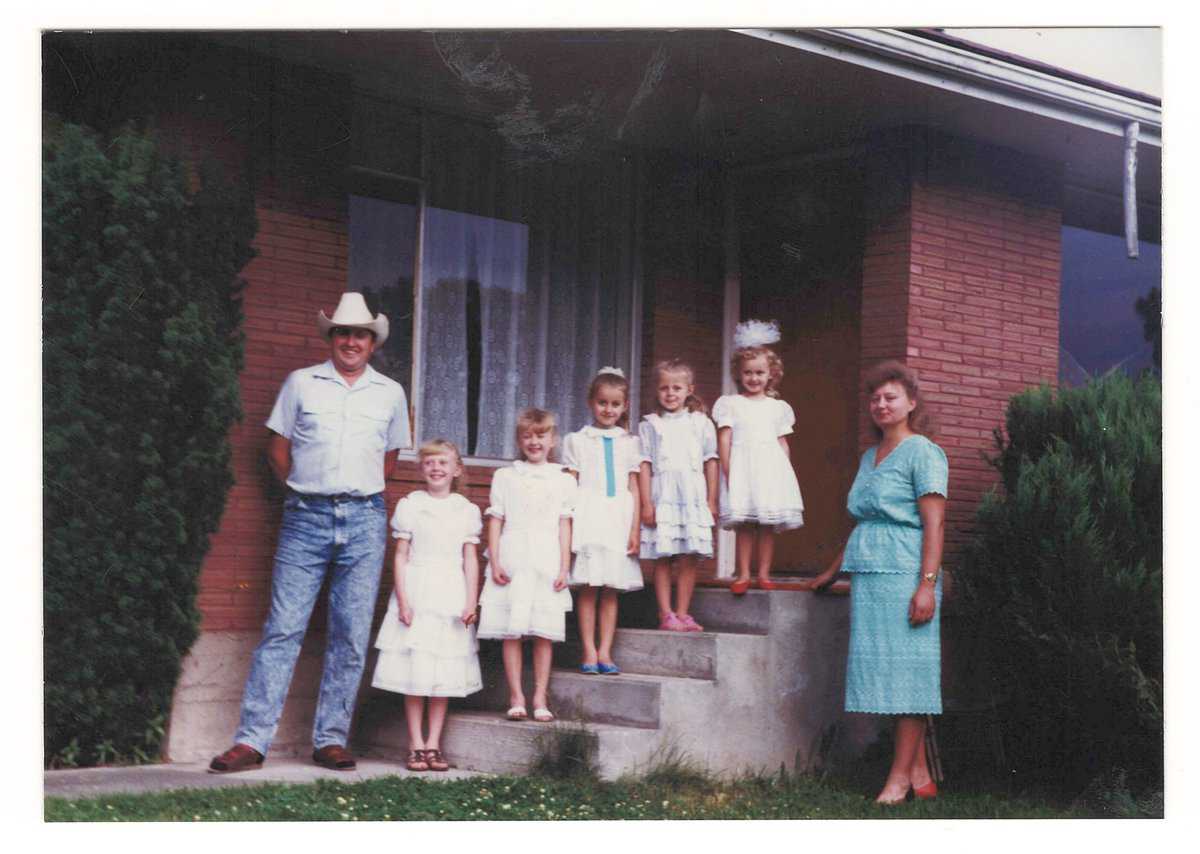 Natasha with family posing on steps next to a house