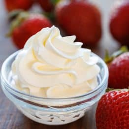 homemade whipped dream piped into a small bowl with strawberries for dipping
