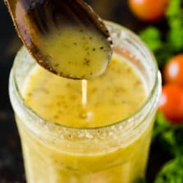 Italian dressing pouring from serving spoon