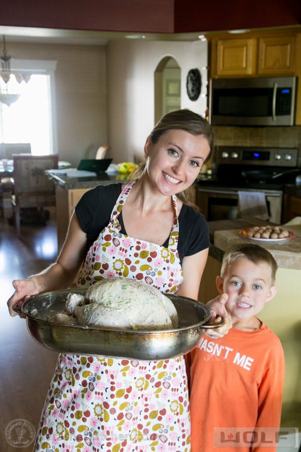 Natasha and son holding turkey prepared for the oven