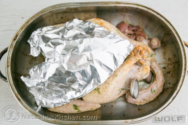 roasted turkey covered with a foil shield