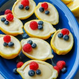 lemon posset recipe served on a blue dish with berry garnish