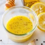 lemon vinaigrette dressing recipe in a clear jar with lemon slice on the side and pepper garnish