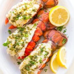Lobster tails on a serving platter served with lemon wedges