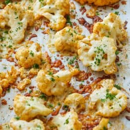 Roasted parmesan cauliflower florets with parsley and crispy, cheesy bits