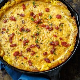 Potato Crust Quiche in a well-seasoned 10-inch cast iron skillet, topped with bacon and parsley