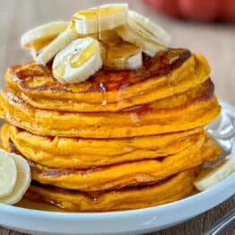 Pumpkin pancakes stacked on a plate