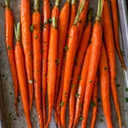 Roasted carrots on a baking sheet with garnish