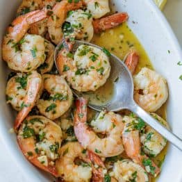Shrimp scampi recipe in a white dish with butter garlic sauce and parsley garnish