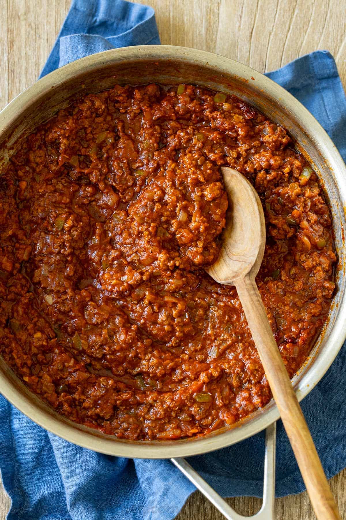 saucy and beefy sloppy joe meat sauce cooked in a skillet with a mixing spoon