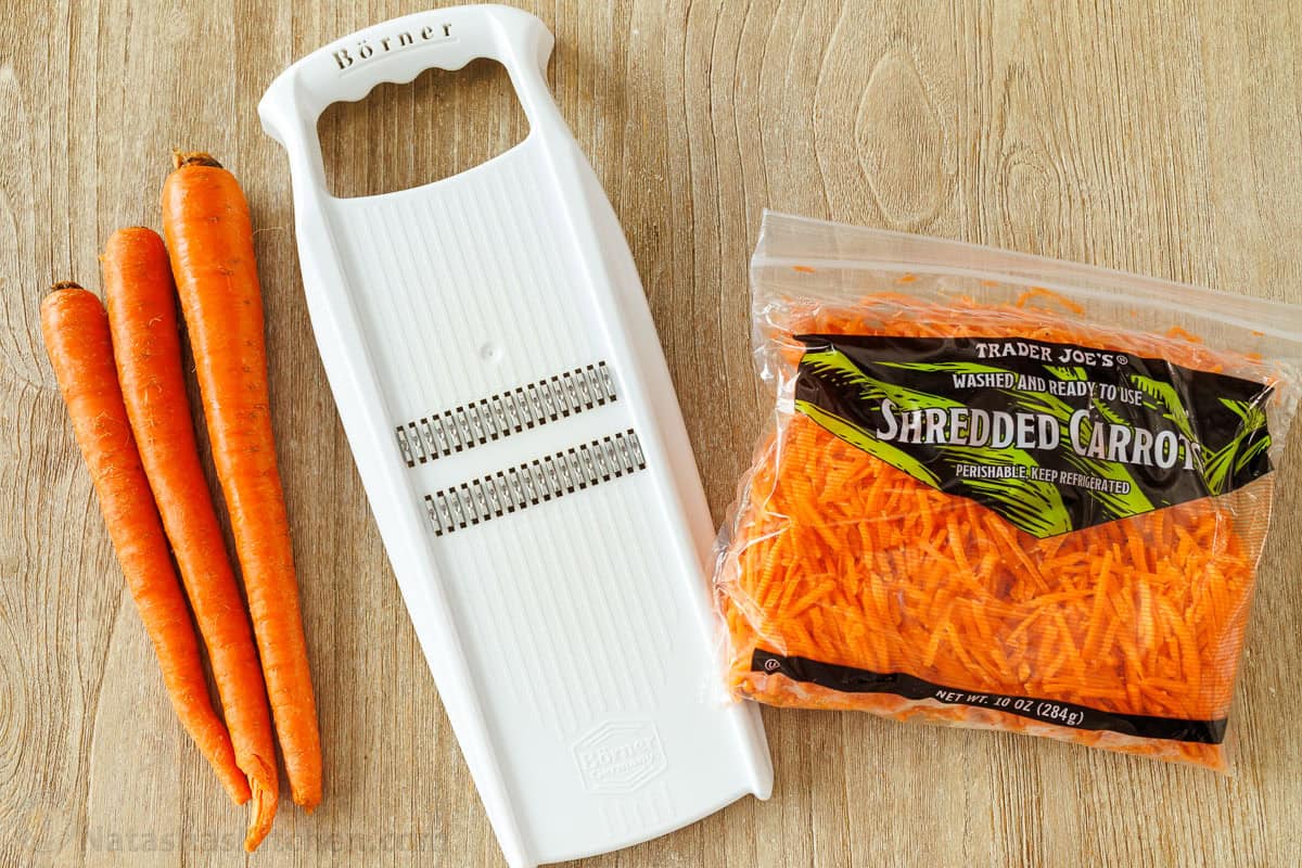 Carrots and and mandolin next to a bag of shredded carrots for Spicy Korean Carrot Salad recipe