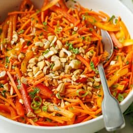 Spicy Korean Carrot Salad recipe with a spoon garnished with cashew nuts