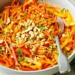 Spicy Korean Carrot Salad with cashews and cilantro garnish on top