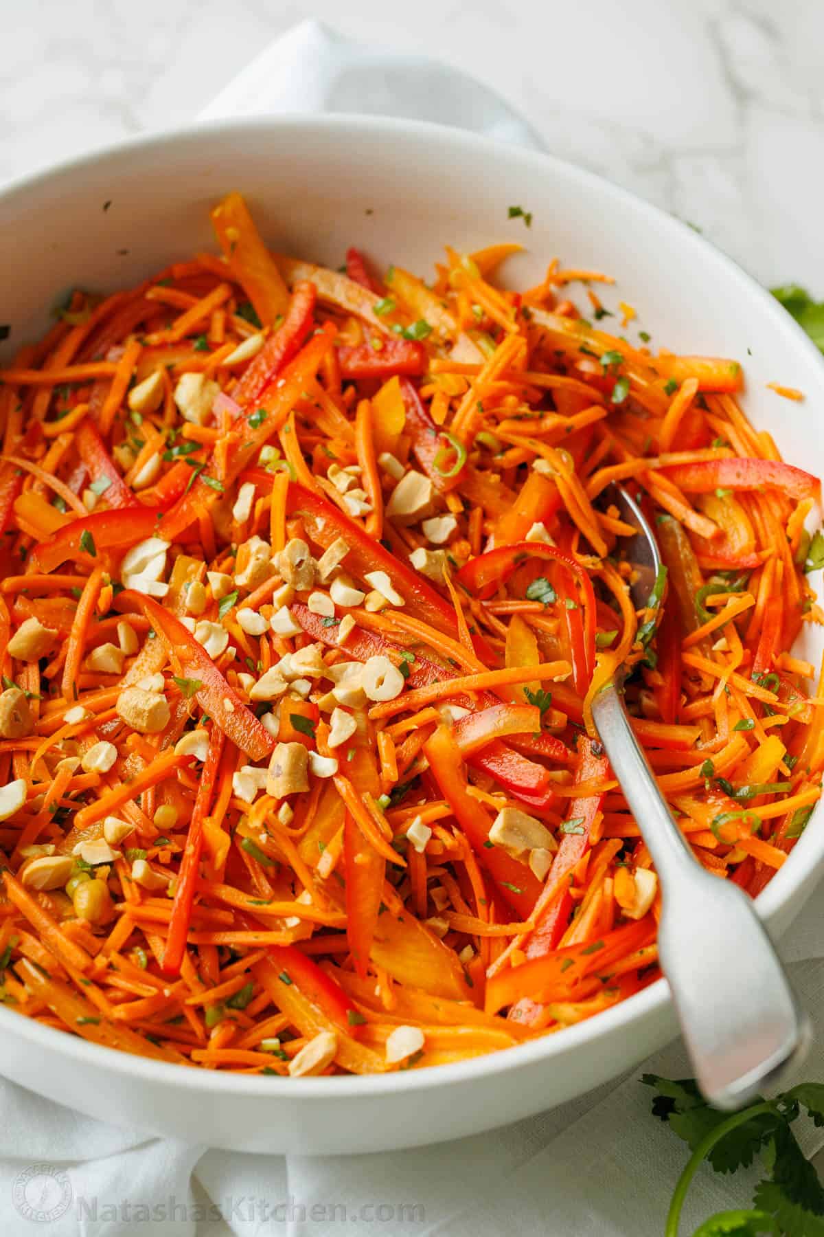 Spicy Korean Carrot Salad in a white bowl with a fork