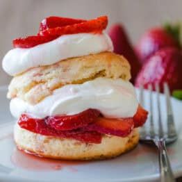classic strawberry shortcake recipe using homemade biscuits, strawberries in sugar and whipped cream