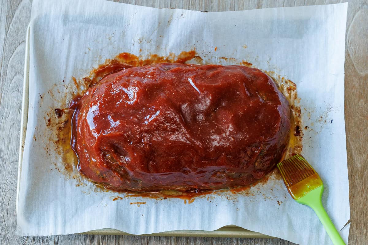 Brushing Sauce over meatloaf