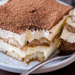Tiramisu cake slice on a plate with a fork